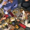 Overhead restaurant table with a black cordless lamp, plates and diners